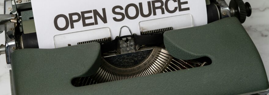 Picture of a typewriter with the words "Open Source" printed on paper on the roller